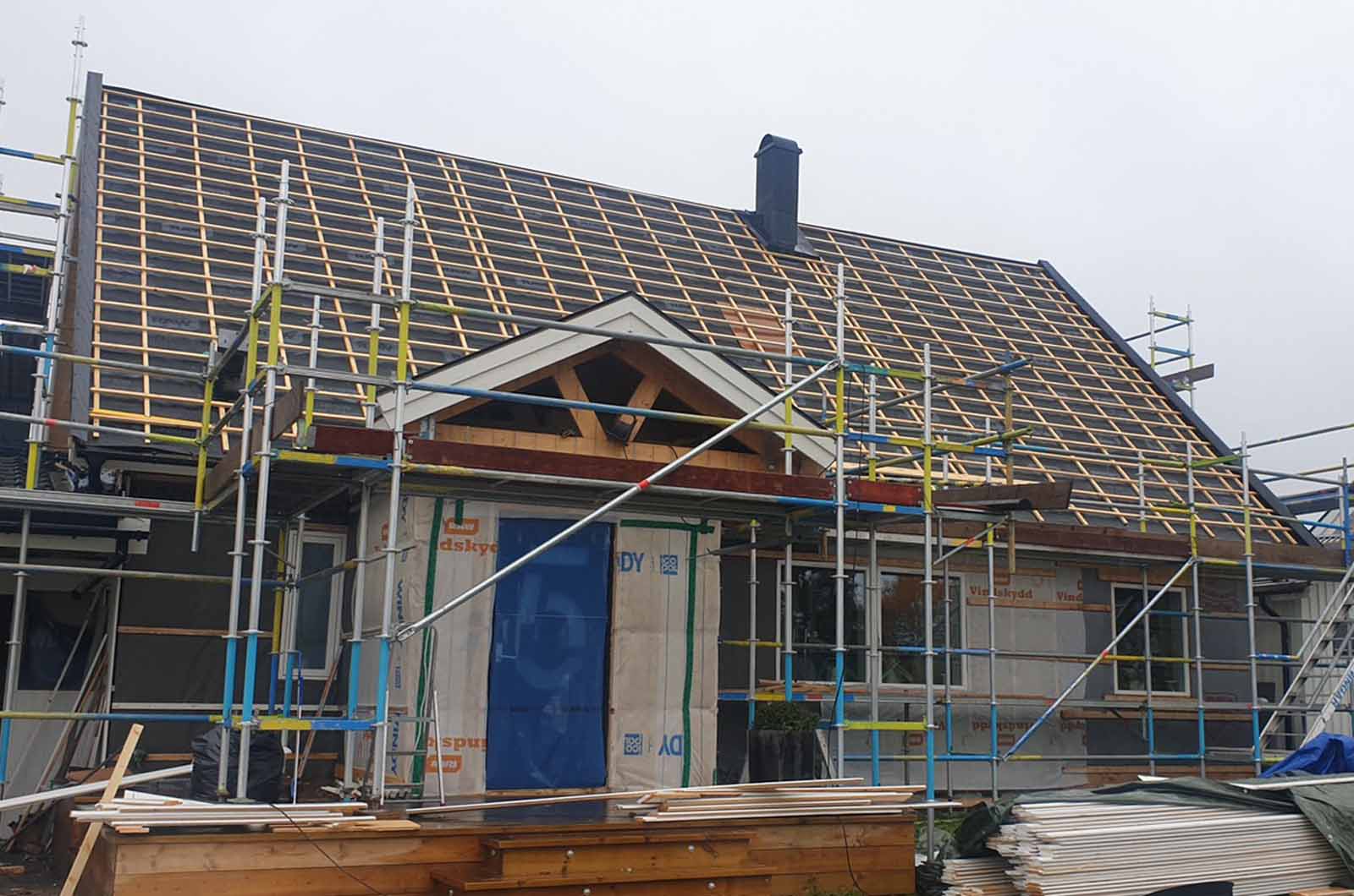 Takomläggning med nya takfönster och takpannor på villa i Hässelby